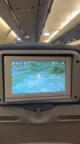 Passenger documents airplane cabin with flight maps over Beijing