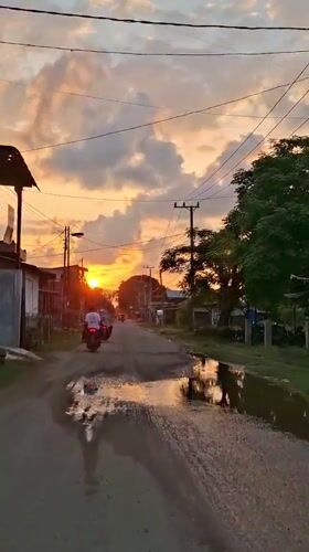 Golden hour settles over a quiet village road in Lhokseumawe