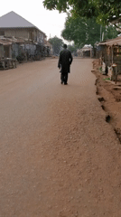 Motorcycle and foot traffic on a Bukuru market road