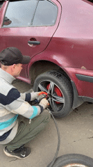 Man uses air wrench on car wheel in Moscow