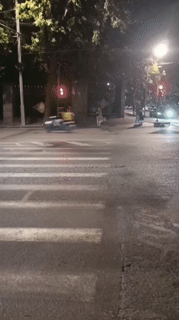 Pedestrians crossing a lit Yerevan street at night