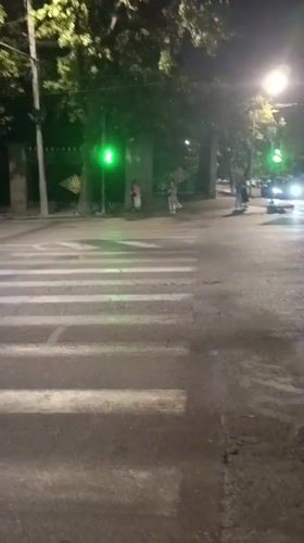 Pedestrians crossing a lit Yerevan street at night