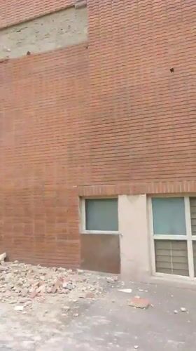 Caracas shopping center facade collapses, debris scattered at entrance
