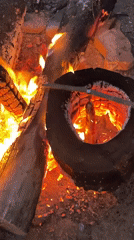 Meat roasting over a tire-fed campfire in rural Russia
