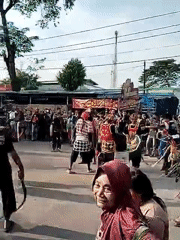 Traditional Indonesian street performance draws onlookers in daytime display