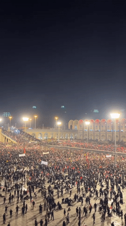 Large crowd gathers in Tehran plaza on summer evening
