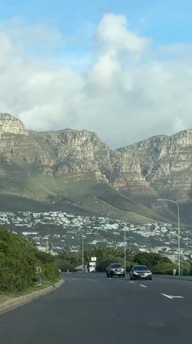 Traffic flows toward Cape Town mountains amid white buildings