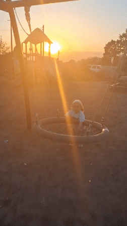 Child plays at sunset playground in Timmolovo, Russia