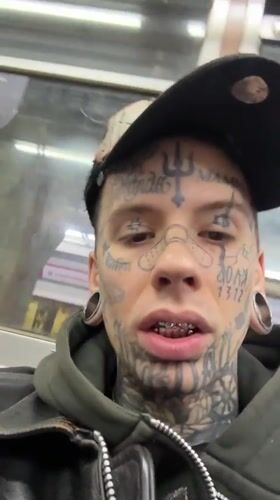 Heavily tattooed face, Buenos Aires streets, late night