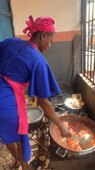 Woman cooks red sauce in kitchen, Obosi Nigeria