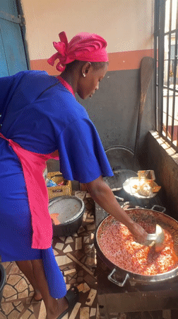 Woman cooks red sauce in kitchen, Obosi Nigeria