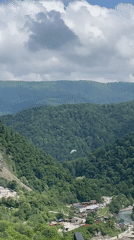 Paraglider spotted over forested mountains near Baranovka, Russia