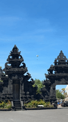 Paragliders spotted over traditional Balinese gate in Kuta Selatan