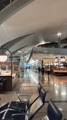 Late night travelers navigate Dubai airport terminal corridors