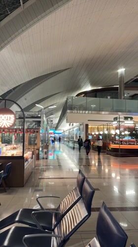 Late night travelers navigate Dubai airport terminal corridors