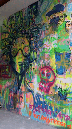 Tourists take selfies at colorful graffiti art spot in Ubud
