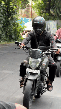 Motorcyclist in black hoodie rides through Ubud District
