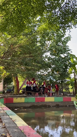 Outdoor group event in Gelam with uniforms, flags, and a painted bridge