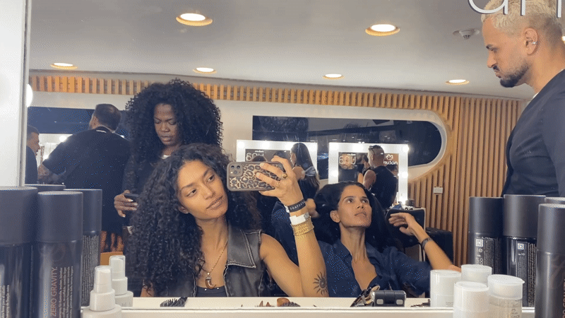 Woman uses phone in Rio salon mirror reflection