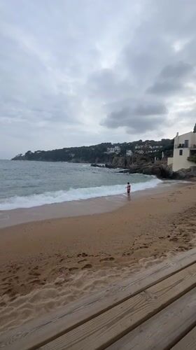 Overcast afternoon brings casual beachgoers to Calella De Palafrugell