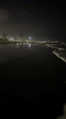 Evening beach scene captured in Đà Nẵng with illuminated cityscape
