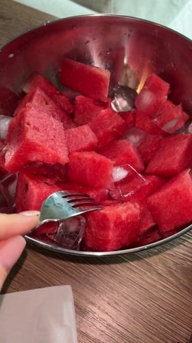 Person enjoys iced watermelon while working on Russian technical documents