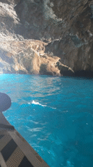 Boat explores turquoise cave near Montenegro's cloudy Luštica coast