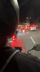 Motorcyclist caught in nighttime traffic jam in Kuta