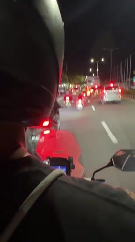 Motorcyclist caught in nighttime traffic jam in Kuta