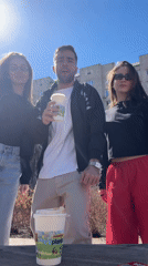 Three young adults socialize outdoors in Krasnoyarsk public area