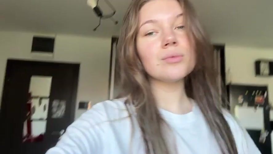 Woman adjusts hair playfully in Belgrade apartment Sunday morning