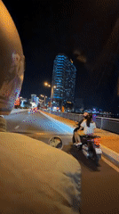 Nha Trang at night: lit bridge, open road, glowing skyline.