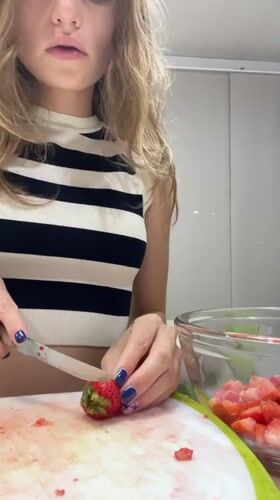 Woman prepares strawberry dish in Mexican kitchen early morning