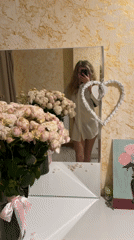Woman documents flower bouquet gift in mirror selfie session