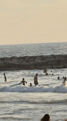 Tel Aviv beach crowd gathers under a golden sunset