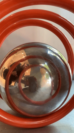 Interactive metal sphere sculpture touched by visitor in Barcelona