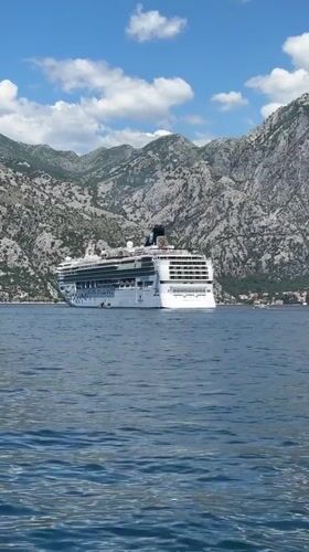 Cruise ship anchored in Montenegro bay amid mountain scenery