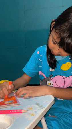 Child coloring at table in Indonesia