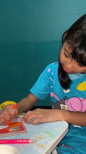 Child coloring at table in Indonesia