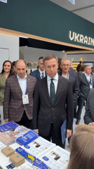 Suited attendees gather at a Ukraine trade or exhibition event