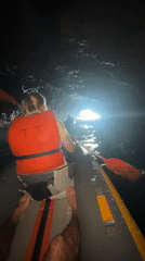 Kayakers explore dramatic coastal cliffs and sea caves