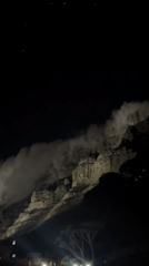 Table Mountain illuminated at night with flowing clouds captured