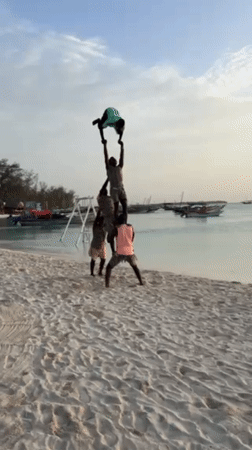 Tourists enjoy beach activities, pyramids at Kendwa Tanzania sunset