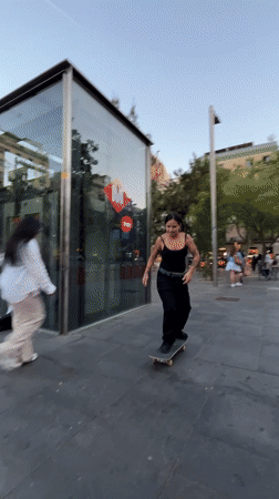Young skateboarders practice tricks in Barcelona plaza during evening session