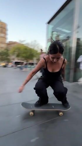 Young skateboarders practice tricks in Barcelona plaza during evening session