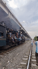 Crowded train and a contrail cutting through a cloudy sky