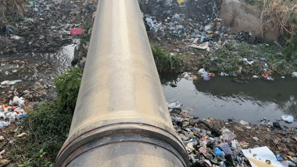 Witness documents heavily polluted waterway with trash-lined banks