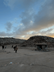 People navigate trash heaps in Gaza during afternoon hours