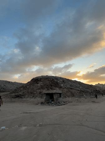 People navigate trash heaps in Gaza during afternoon hours