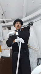 Person in Charlie Chaplin costume spotted indoors near clothing rack